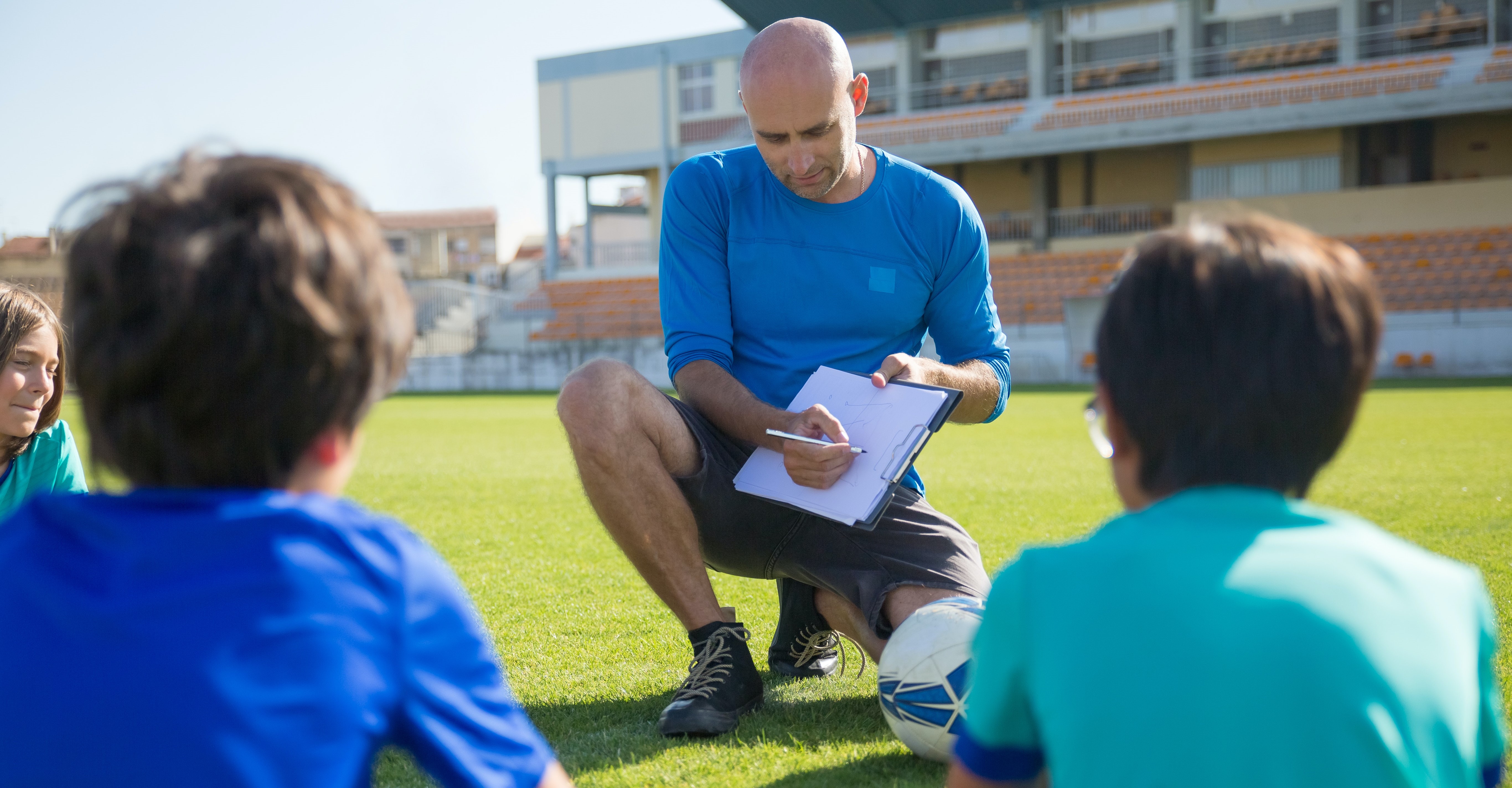 Soccer coach on the field talking to young soccer players