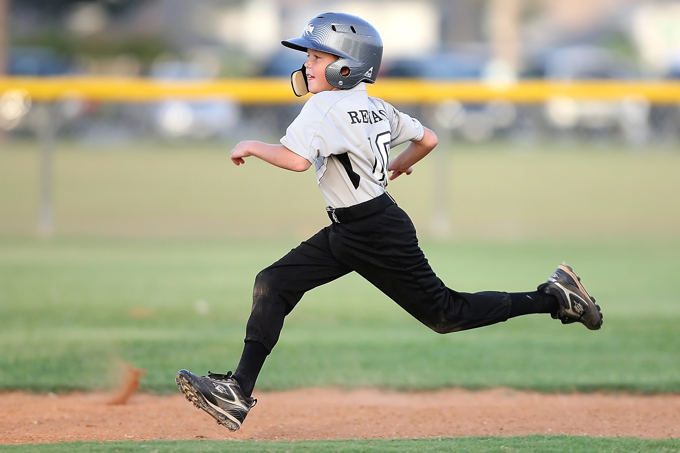 Young baseball player running to the next base