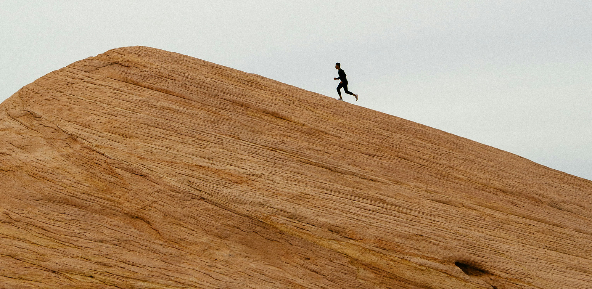 Long shot of a man running up a an incline