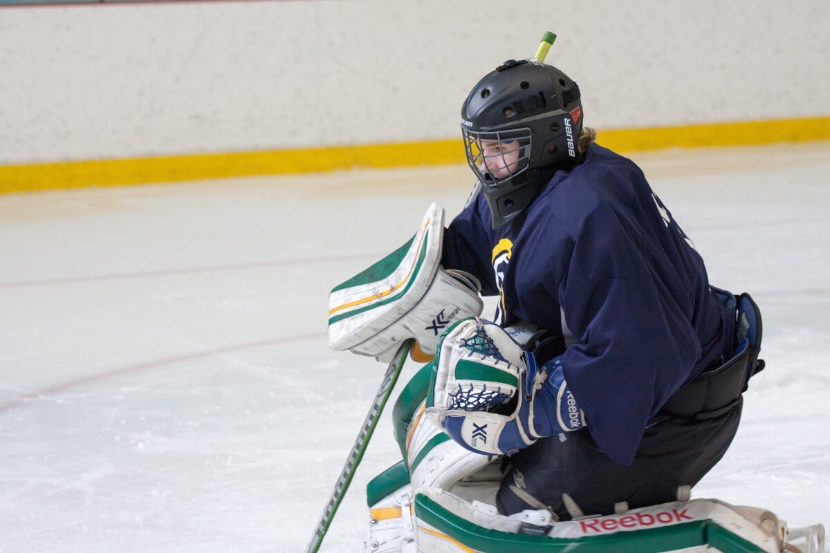 Young hockey goalie preparing for a save